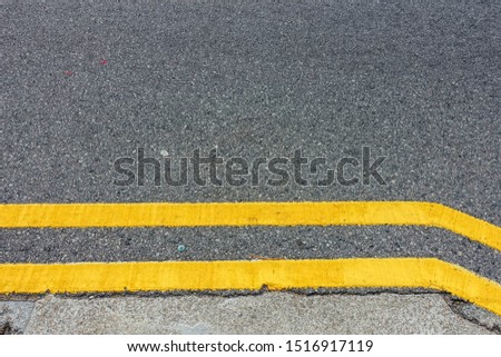Yellow double solid line on the asphalt road.