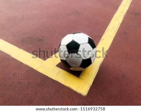 old and damaged ball at corner of futsal court