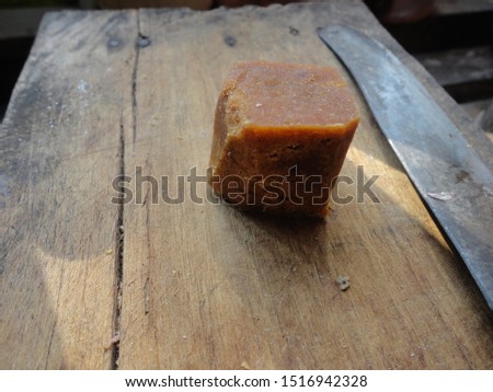 Close-up of red sugar or palm sugar with a knife and sunlight in the afternoon on the wood