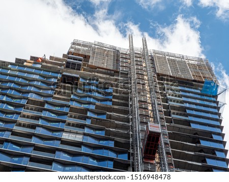 Building and construction scene. Work site elevator during the construction of a building. Scaffolding in construction site. Royalty-Free Stock Photo #1516948478