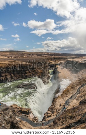 A three-step staircase of the Gullfoss waterfall on Hvita river, as pictured in  detail (water plunging into the canyon, mossy cliffs, thick spray, panorama of the rapids) 
