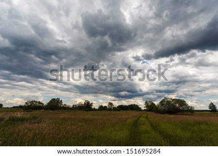 Stormy cloudscape over meadow, Poland, Europe