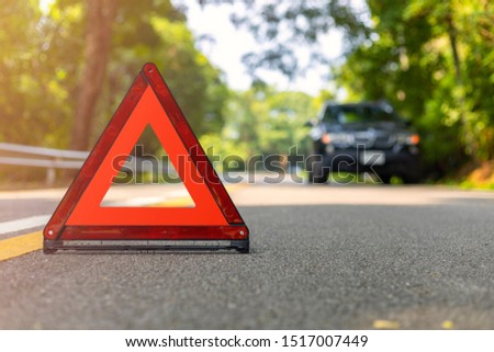 Red triangle, red emergency stop sign, red emergency symbol and black car stop and park on road.