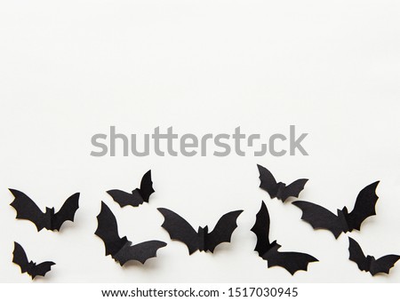 halloween  concept - black paper bats flying over grey background
