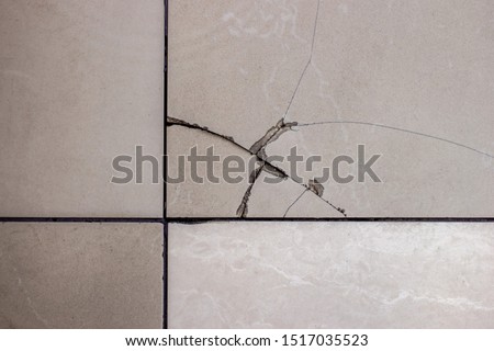 Cracked tile. Broken tile on the floor. Royalty-Free Stock Photo #1517035523