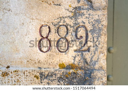 House number eight hundred and eighty two (882) engraved in stone