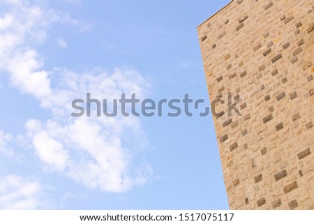 Part of the building against the blue sky. The wall against the blue sky
