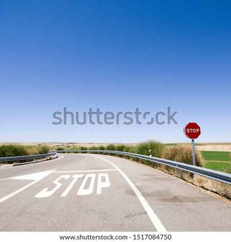 Stop sign and written on the ground with a blue sky