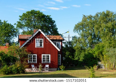 Traditional red wooden house in Sweden on the island Oland, in the summer. The house is surrounded by a beautiful, summery garden Royalty-Free Stock Photo #1517102051