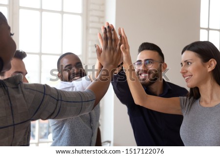 Head shot overjoyed multiracial young business team members giving high five, celebrating important company achievement or shared success, satisfied with great project results or outstanding teamwork. Royalty-Free Stock Photo #1517122076