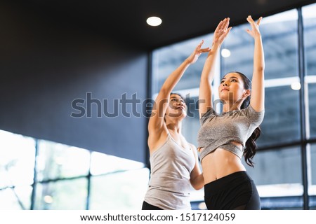 Beautiful Asian woman learning yoga pose with female instructor in yoga studio or health club. Sport exercise activity, gymnastics or ballet dancing class, or healthy people lifestyle concept Royalty-Free Stock Photo #1517124059