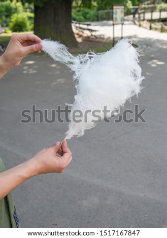 a man eating cotton candy by hand