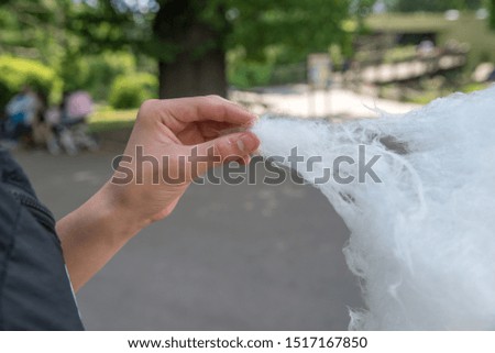 a man eating cotton candy by hand