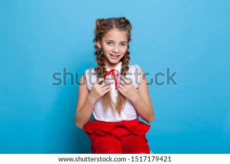 Schoolgirl girl in red white dress on a blue background