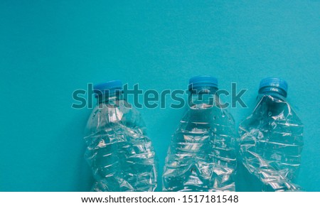 Plastic water bottles on blue background to represent concept about ecology and single use plastic  Royalty-Free Stock Photo #1517181548