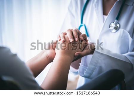 The doctor hold hands patient Which sat on wheelchair to encourage To fight the disease And cheer to receive treatment, to health care concept. Royalty-Free Stock Photo #1517186540