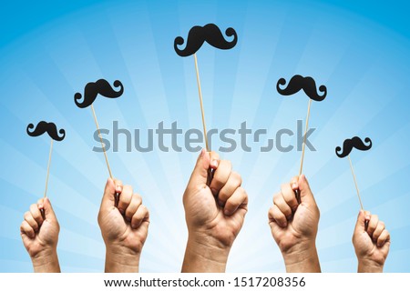 Hands holding Photo booth props, Black Mustache and rising them up Royalty-Free Stock Photo #1517208356
