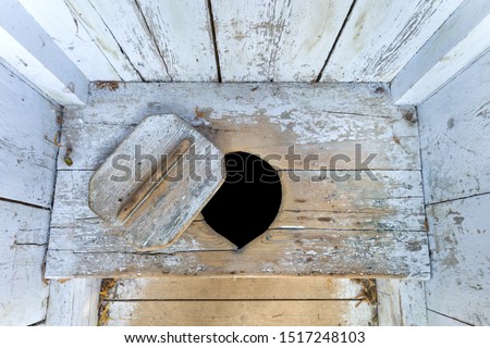 interior of an old wooden outhouse Royalty-Free Stock Photo #1517248103
