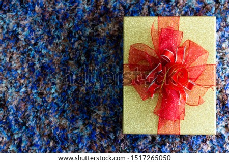 A gift box for someone special, tied with a ribbon, placed on the floor Ideas to welcome the upcoming Christmas season.