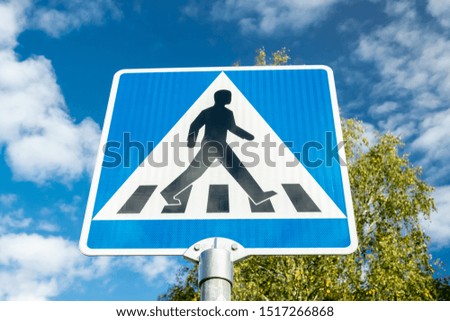 Pedestrian crossing road sign on blue sky background