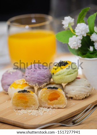 Chinese pastry Moon cake or Mochi or Chinese pastry-bean cake White sesame on Wooden trays and decorative flowers.
