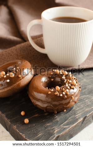 Chocolate donuts with glaze and crispy balls on dark wooden board