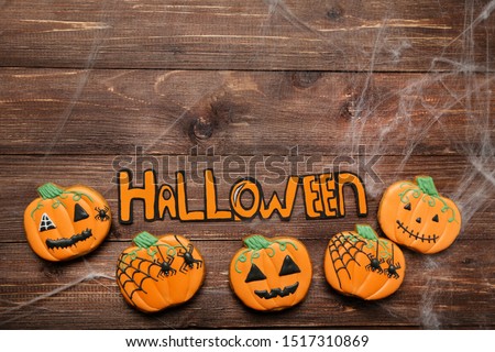 Gingerbread cookies with text Halloween on brown wooden table