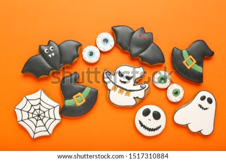 Halloween gingerbread cookies on orange background