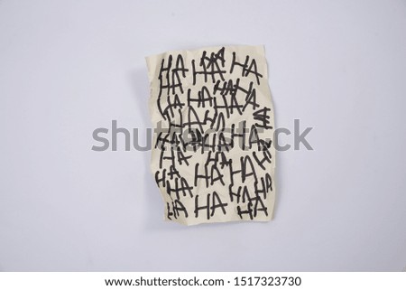 isolated creepy laughter Ha Ha written on paper on white background
