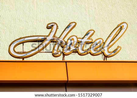 Signboard of a hotel. Hotel word with golden letters on hotel.