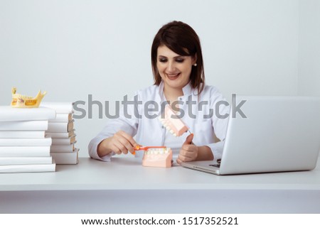 Dentist woman working sitting in office isolated with dental staff.