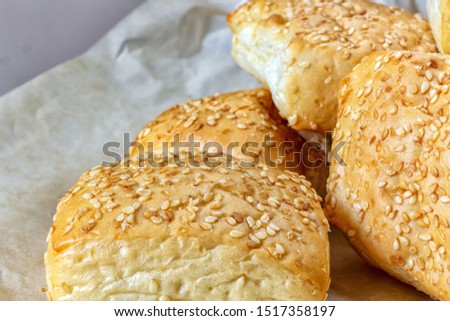 Sesame seeds on a Golden crust of Milanese buns, on a parchment sheet