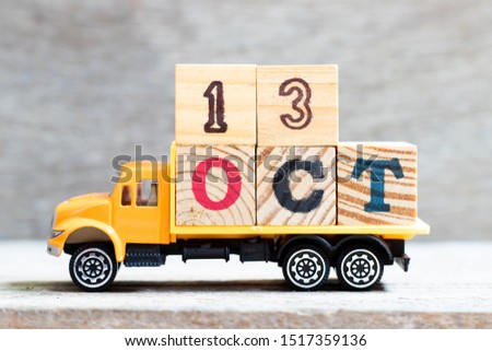 Truck hold letter block in word oct on wood background (Concept for date 13 month October)