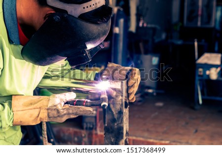 Male workers are using TIG welding machines to weld stainless steel frames in the factory.