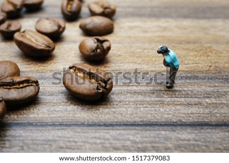 Miniature photographer take a picture of coffee beans 