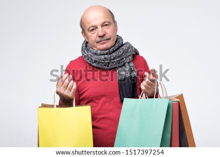 Shopping, consumerism, sale concept. Tired caucasian man with paper bags after shopping feeling tired and exhausted. Studio shot