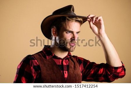 i got my eye on you. man checkered shirt on ranch. cowboy in country side. Western. Vintage style man. Wild West retro cowboy. western cowboy portrait. wild west rodeo. Handsome man in hat.