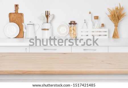 Blurred kitchen counter with utensils and ingredients over wooden table Royalty-Free Stock Photo #1517421485