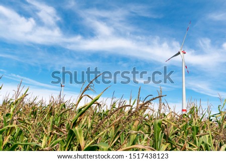 Wind turbine in front of blue cloudy sky Royalty-Free Stock Photo #1517438123