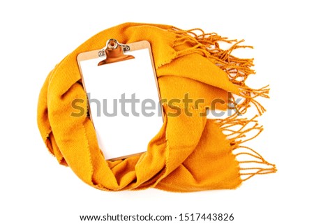 Flat lay autumn composition with notepad and a warm woolen scarf. Comfort warm clothers for the cold weather. Copy space