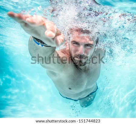Young man swimming the front crawl in a pool, taken underwater Royalty-Free Stock Photo #151744823