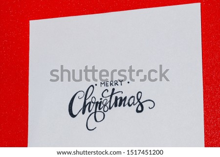 red background of merry christmas written on paper