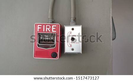 Manual fire alarm, manual pull station of fire alarm system and fire fighters telephone on the wall near fire exit door or along of corridor in condominuim , apartment. Safety equipment concept. 