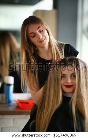 Woman Hairdresser Making Hairstyle for Girl Client. Hairstylist Styling Volume Haircut with Hands. Female Stylist Touching Hair of Customer. Two Beautiful Blonde Girls in Beauty Salon Photography.
