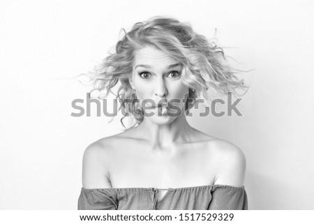 Black and white closeup portrait of a woman with foolish grimace isolated at white background. Concepy of joy and careless lifestyle. Funny emotion.