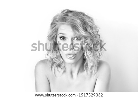 Closeup black and white portrait of a woman with foolish grimace showing tongue isolated at white background. Concepy of joy and careless lifestyle. Funny emotion.