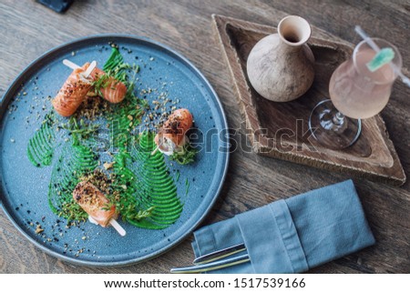 Food photography, delicious salmon bite with cream-cheese and avocado sauce on the table.