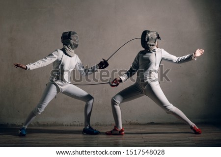 Fencer woman with fencing sword. Fencers duel concept. Royalty-Free Stock Photo #1517548028