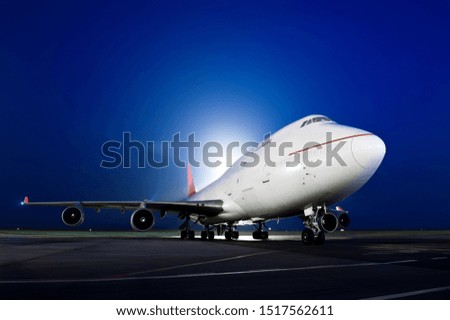 The plane stands at the airport at night by the light of lanterns