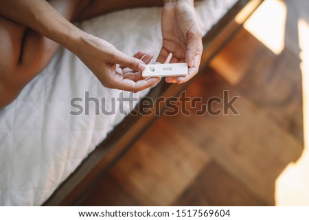 Close up of female hands holding pregnancy test
